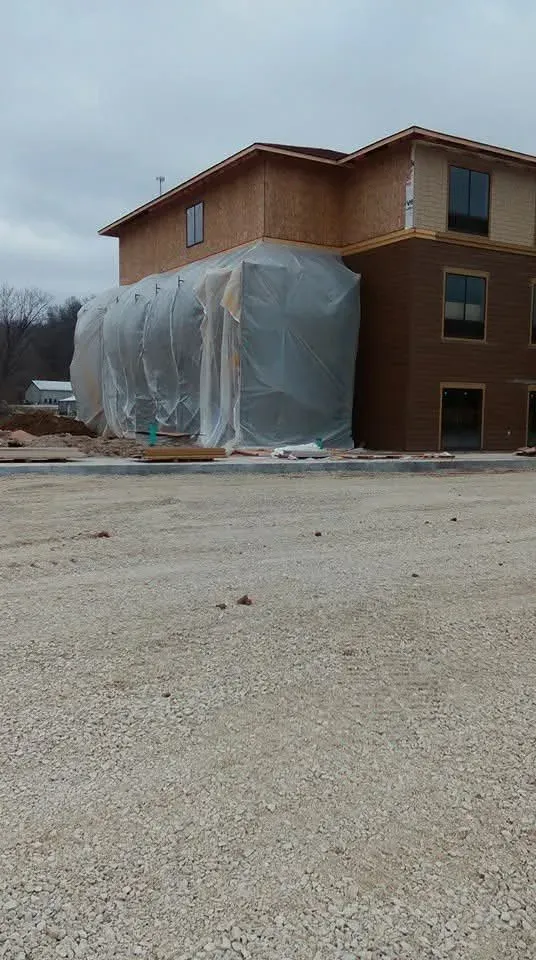 One wing of the Indiana hotel project wrapped in plastic sheeting beside a finished section of the building