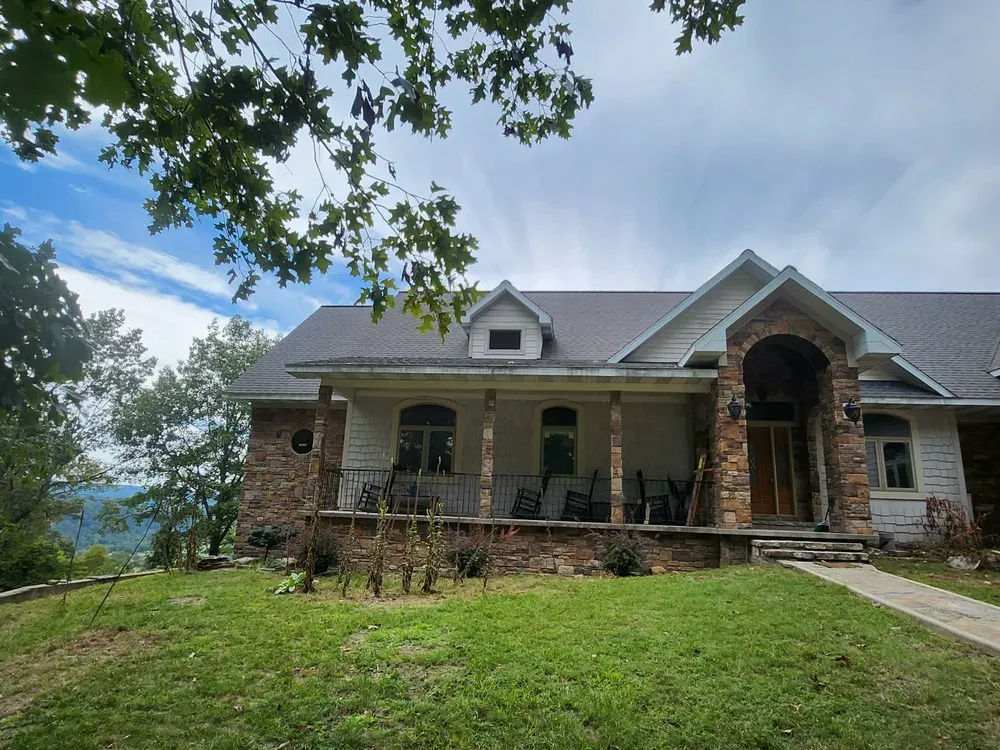 Home front with porch pillars and entry arch clad in Walnut Ridge ledge stone