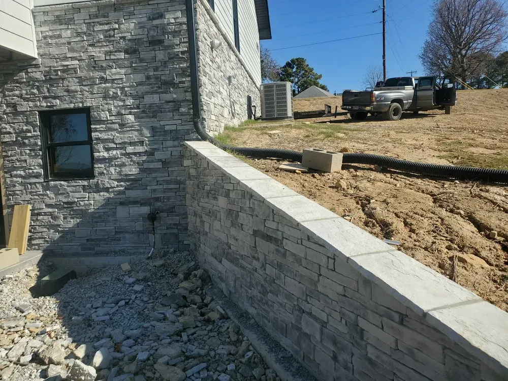 New-build corner in European Drystack, Ozark Gray, beside a retaining wall with 13 by 20 cap stones