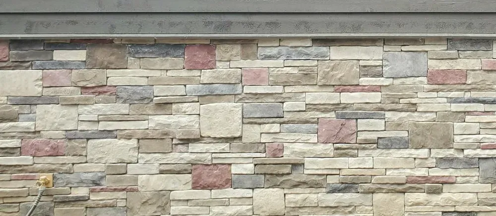 Close-up of light mixed ledge stone with rose accent pieces